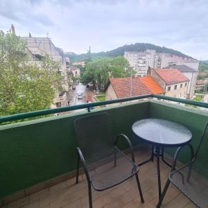 uma mesa e cadeiras numa varanda com vista em Apartment ZORA em Knin