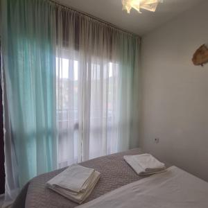 1 dormitorio con 1 cama y ventana con toallas en Apartment ZORA en Knin