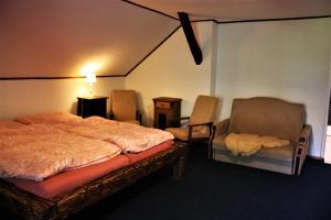 1 Schlafzimmer mit einem Bett, 2 Stühlen und einem Tisch in der Unterkunft U Lesíčka in Vysoká