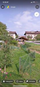 uma vista para um quintal com uma cerca e uma casa em Passione Dolomiti em Romeno