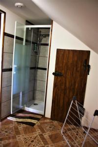 a bathroom with a shower and a wooden door at U Lesíčka in Vysoká