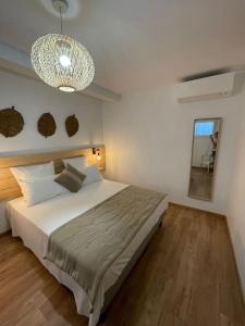 Un dormitorio con una cama grande y una lámpara de araña. en La maison du Port Apt MARSA, en Marseillan