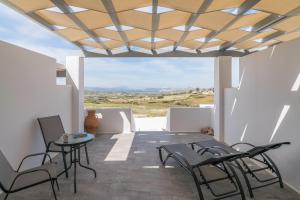 a room with a table and chairs on a balcony at Sunset Village 2 in Paleochori