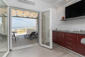 a kitchen with a sliding glass door leading to a patio at Sunset Village 2 in Paleochori +10 photos