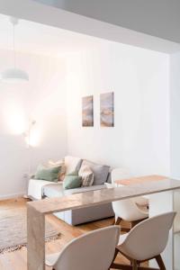 Amaro - Elegant 2 bedroom apartment in Alcantara في لشبونة: غرفة معيشة مع طاولة وأريكة