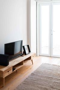a living room with a flat screen tv on a wooden table at Amaro - Elegant 2 bedroom apartment in Alcantara in Lisbon