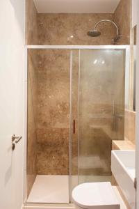 a bathroom with a shower with a toilet and a sink at Amaro - Elegant 2 bedroom apartment in Alcantara in Lisbon