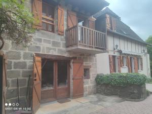 Les colombages bis في Pazayac: مبنى بأبواب خشبية وشرفة