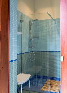 a glass shower with a chair in a bathroom at Guesthouse PoortAckere Ghent in Ghent