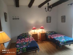 um quarto com duas camas e dois candeeiros em Les colombages bis em Pazayac