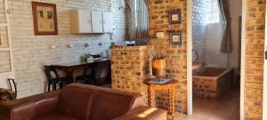 a living room with a couch and a kitchen with a counter at Green Thumb Farm Stay in Ermelo