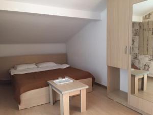 a small bedroom with a bed and a table at Vila Patricia in Eforie Nord
