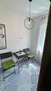 Habitación con 2 sillas, mesa, mesa y sillas. en Apartman Reyan en Jajce