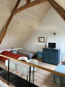 a attic room with a bed and a tv at Kerhoki in Le Vivier-sur-Mer