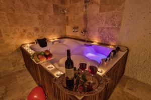 a bath tub with wine glasses and wine bottles at CaveAdocia in Nevşehir