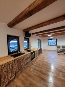 een lege keuken met houten vloeren en ramen bij Dom we wsi - Wioska Mnicha in Knyszyn