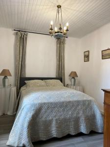 a bedroom with a bed and a chandelier at Kerhoki in Le Vivier-sur-Mer