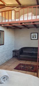 a living room with a couch under a loft bed at Green Thumb Farm Stay in Ermelo