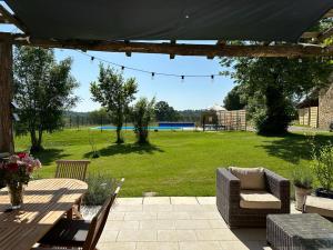 a patio with a table and chairs and a field at Maison d'Amis Des Hirondelles in Lempzours