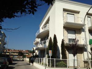 - un bâtiment blanc avec balcon dans une rue dans l'établissement Homiday - Bordopineta Residence, à Pineto