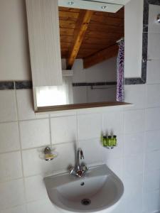 La salle de bains est pourvue d'un lavabo blanc et d'un miroir. dans l'établissement Chloe attic, à Agia Effimia
