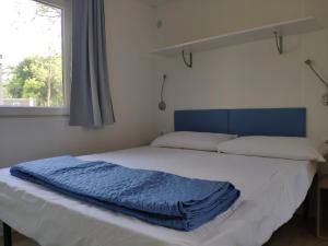 ein Bett mit blauer Decke in einem Schlafzimmer in der Unterkunft Camping Sassabanek in Iseo