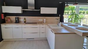 a kitchen with white cabinets and a sink at Gîte rural "l'Anseromia" in Dinant