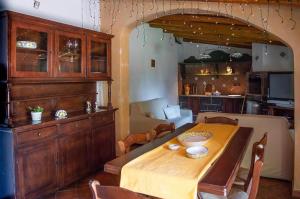 a dining room with a table and a kitchen at La Villa di Tenute Foti Randazzese in Nicolosi +33 photos
