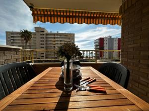 una mesa de madera con un jarrón de flores en el balcón en Excelente ubicacion con vistas al mar en Alicante