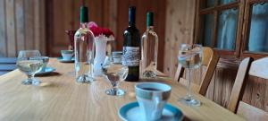 una mesa de madera con botellas de vino y copas. en Guest house Lailashi, en Surmushi