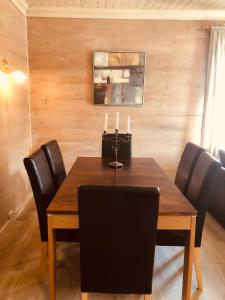 una mesa de comedor con sillas negras y velas. en Apartment with lake view in Jølster en Årdal