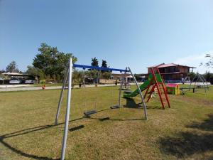 um parque infantil vazio com baloiços num parque em Ktima Argiri em Ormos Panagias