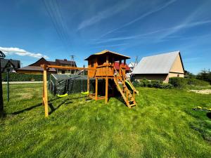 um parque infantil com um escorrega num campo de relva em Domek Góralski na Ubocy z jacuzzi em Białka Tatrzanska