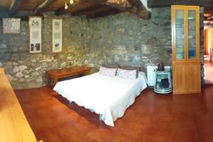 - une chambre avec un lit et un mur en pierre dans l'établissement Descanso en Burgozarre, à Mungia