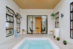 a pool in the middle of a room with chairs and a table at Bali-inspired Villa with Dipping Pool by Pallet Homes in Iloilo City