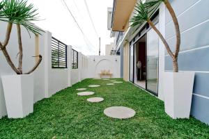 a hallway with artificial grass and palm trees at Bali-inspired Villa with Dipping Pool by Pallet Homes in Iloilo City