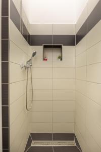 un bagno con doccia e piastrelle bianche e nere di SZ63 Szondi Apartment a Budapest