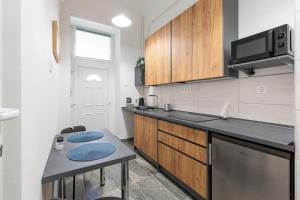 una cucina con armadi in legno e piano di lavoro di SZ63 Szondi Apartment a Budapest
