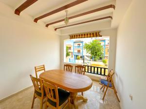 uma sala de jantar com uma mesa e cadeiras e uma janela em Grand appartement en face à la mer avec piscine. em Oued Laou