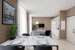 a dining room with a white table and chairs at beautiful 3 room-flat near palais in Cannes