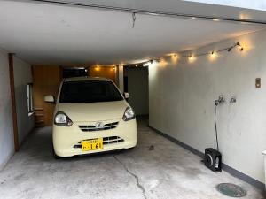 a white car is parked in a garage at Tsukiyume Kan - Entire Private House, Free Parking, 10min USJ & Tennoji, Airport Direct Train, Family Group Sleeps 8, 和モダン貸切一軒家 ユニバーサルスタジオ in Osaka