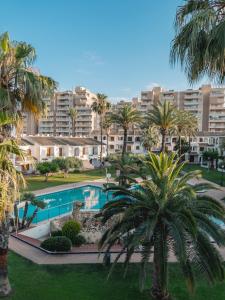 widok na basen z palmami i budynkami w obiekcie Aldeas Taray Admer 1 w mieście La Manga del Mar Menor