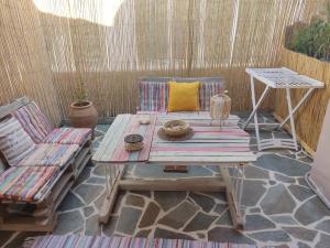 un patio con mesa de madera y sillas en Votsalon Beach House en Katastárion