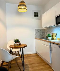 a small kitchen with a table and a chair at Sunshine Getaway - Stylish Studio in the Heart of Nice in Nice