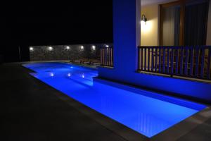 a swimming pool lit up in blue at night at Agriturismo Gradec in Aurisina