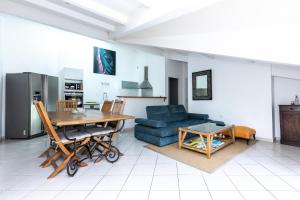 een woonkamer met een tafel en een blauwe bank bij Grand Appartement De Standing in Seignosse