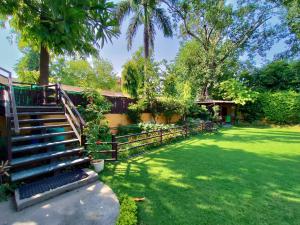 a fence and stairs in a yard with trees at Cp Villa - Rooms with Patio in New Delhi
