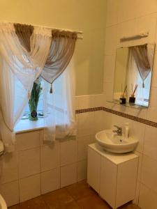 a white bathroom with a sink and a window at Clinton’s cottage in Leitrim