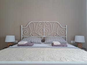 a bedroom with a large bed with two lamps at Apartmani Mostina near river in Ploče