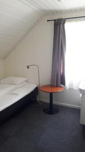 a room with a bed and a table and a window at Lunde Turiststasjon in Skei